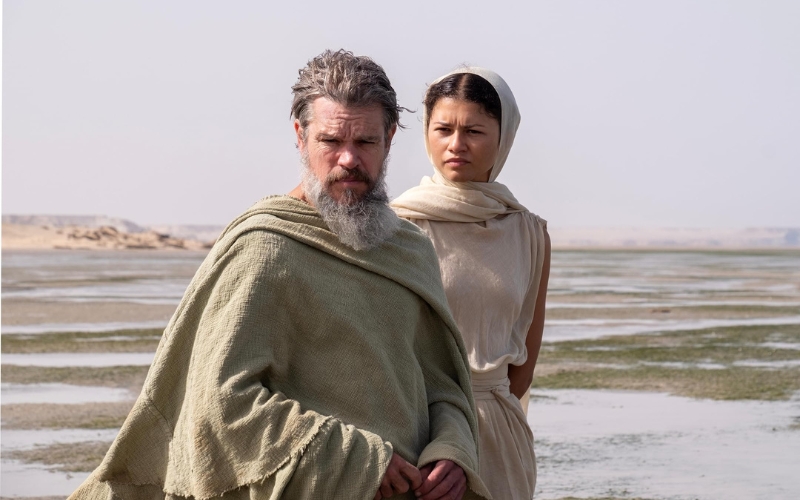 Cena do filme A Odisseia. Odisseu ao lado de Atena em um deserto.
